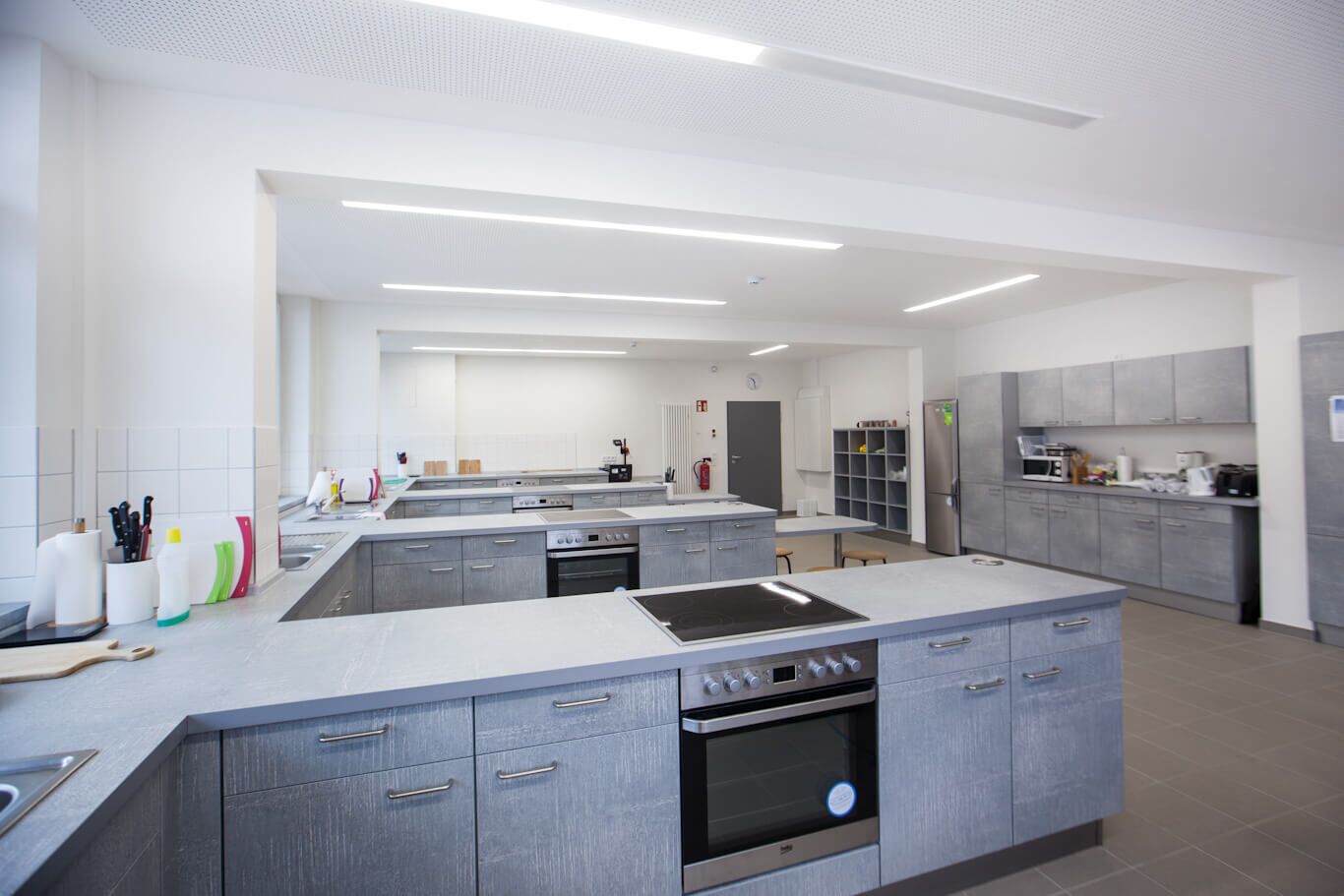 Blick in den neu gestalten Raum für den Hauswirtschaftsunterricht mit mehreren Küchenzeilen